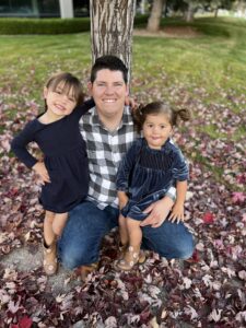 Stuart crouches down for a photo with Adrienne's two little girls.